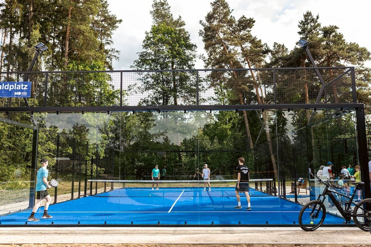 Spieler auf dem von Kiefern umgebenen Outdoor-Padelcourt von Padel Point Konradsreuth