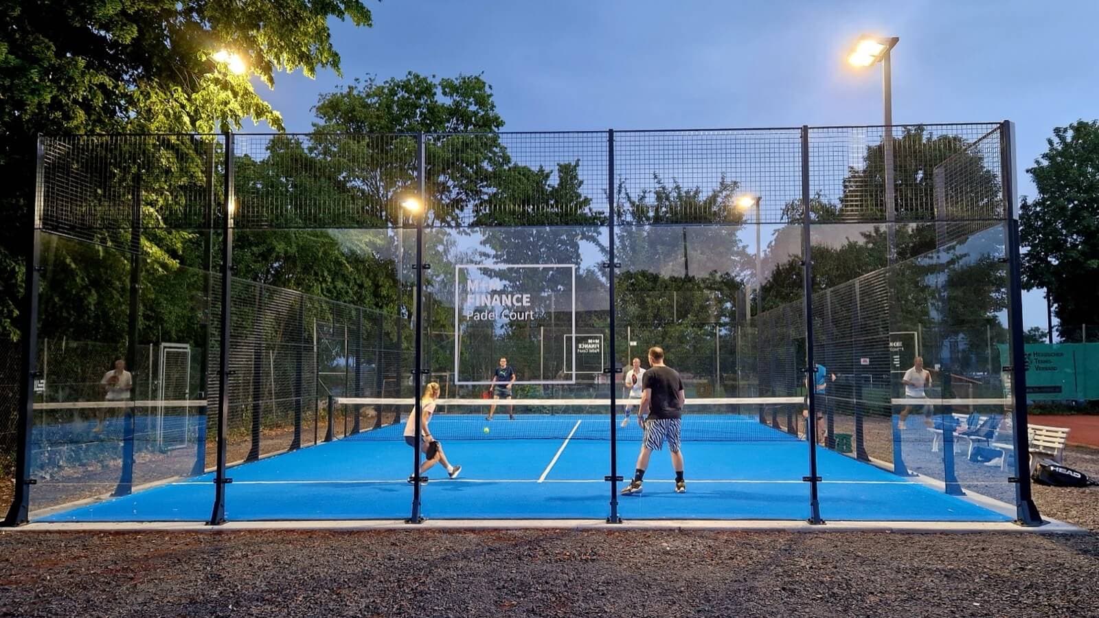 Beleuchteter Outdoor-Padelcourt des TC Neuberg mit vier Spielern am Abend